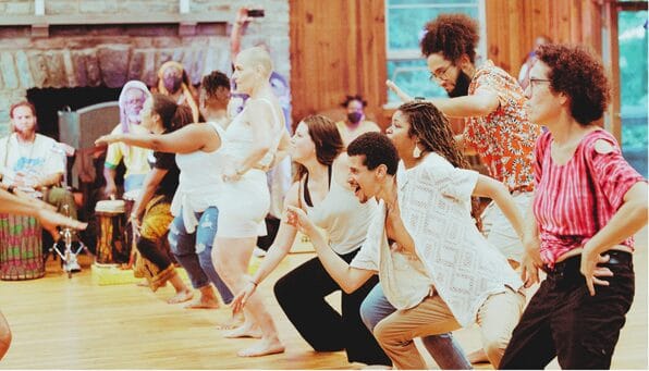 Group of people doing movement and performative warm up